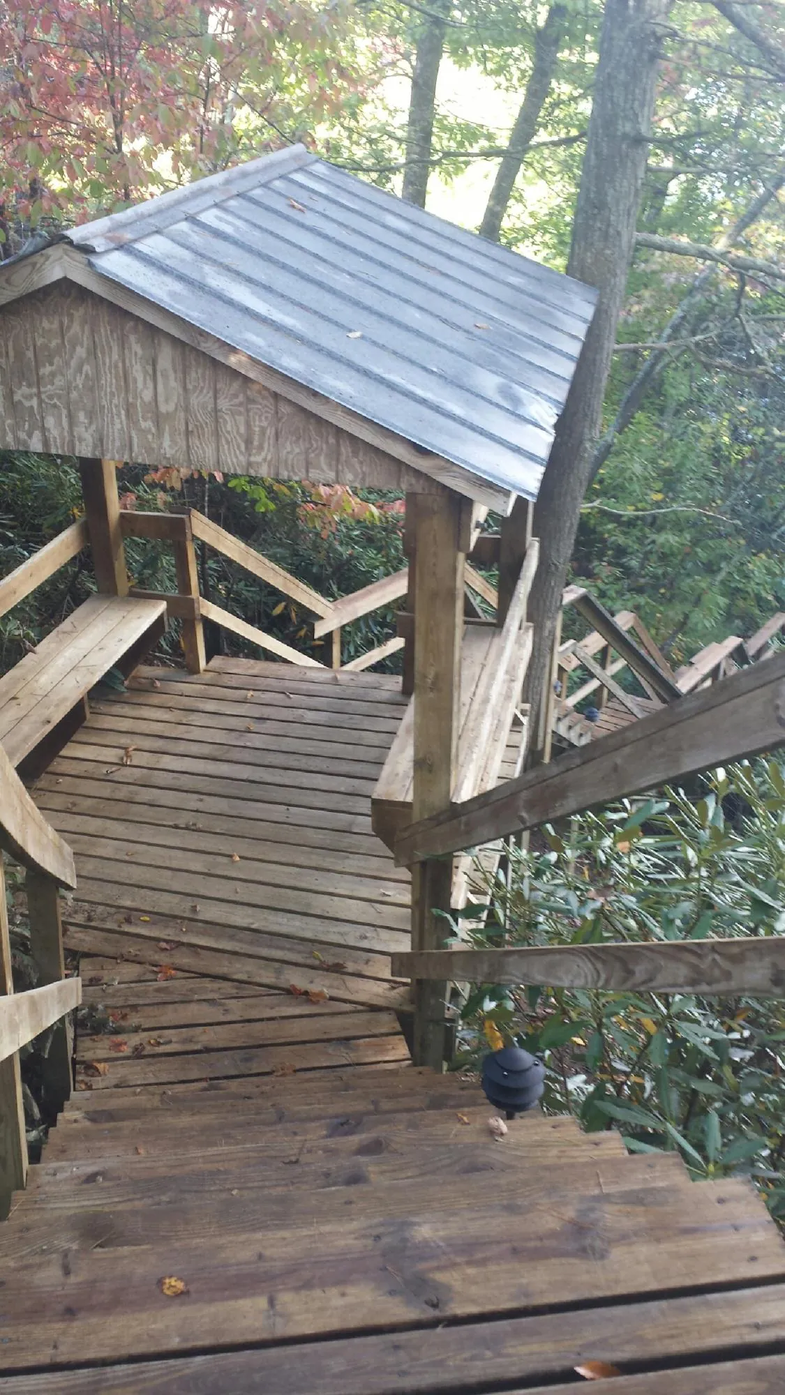 Metal roofed shelter over wooden steps on a wooded walkway — Skylight Repair & Installation work by our crew in New London